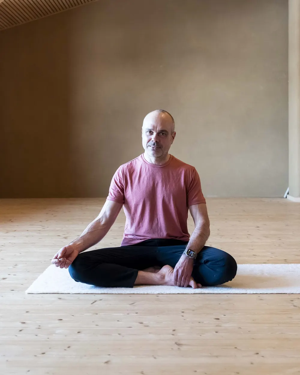 Robert Mittl, Atemcoach und Oxygen Advantage Instructor, sitzt ruhig im Schneidersitz im Seminarraum