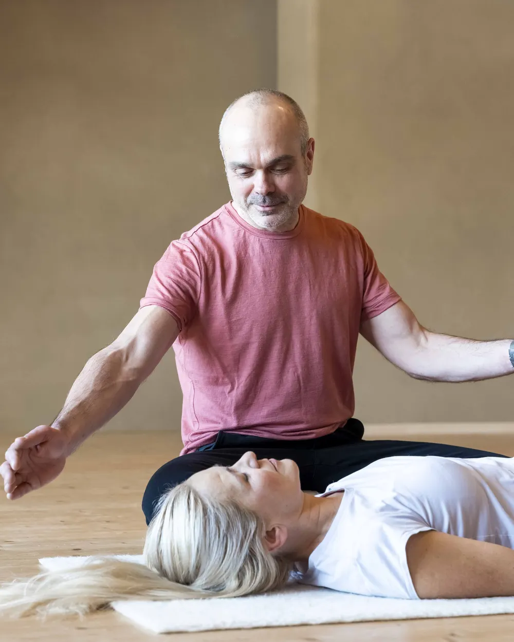 Conscious Connected Breathing: Robert Mittl öffnet die Arme über einer liegenden Klientin und hält den Raum